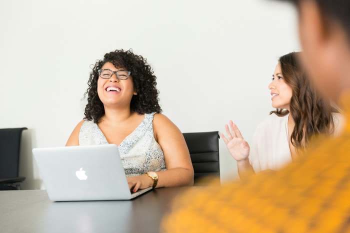 Two colleagues enjoying working together at laptops